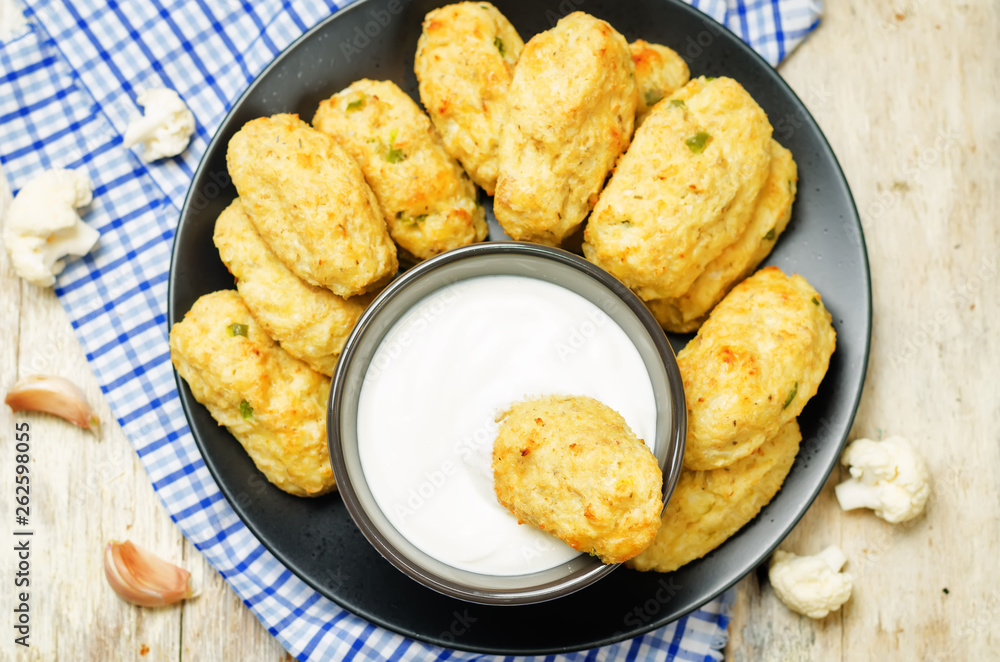 Baked cauliflower Tots on a wood background Baked cauliflower Tots on a wood background