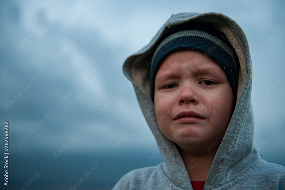 Upset child playing in field sown with winter wheat against backdrop of rain clouds. Tradition of respect for nature, sports and harmonious life. Upset child playing in field sown with winter wheat against backdrop of rain clouds. Tradition of respect for nature, sports and harmonious life.
