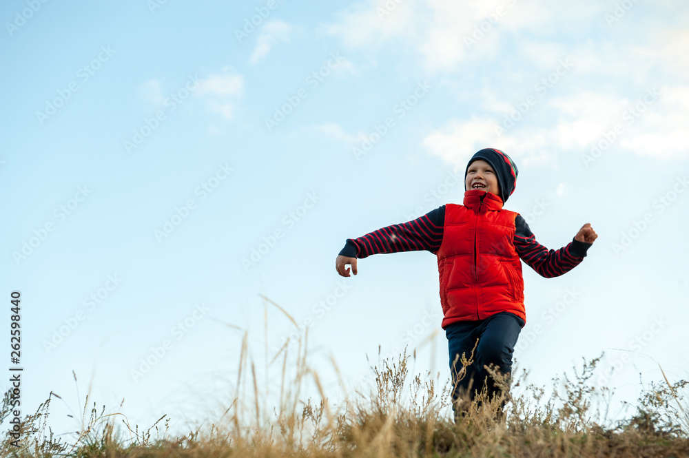 happy child playing in field sown with winter wheat against backdrop of rain clouds. Brothers have fun on vacation in village. Tradition of respect for nature, sports and harmonious life. happy child playing in field sown with winter wheat against backdrop of rain clouds. Brothers have fun on vacation in village. Tradition of respect for nature, sports and harmonious life.