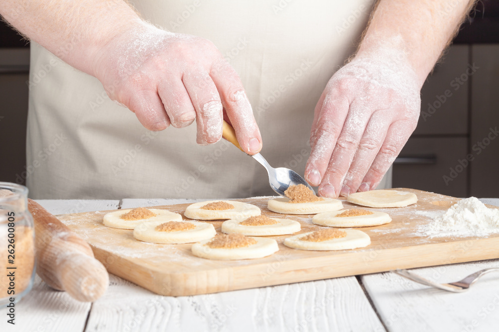 cooking and home concept - close up of hands making cookies from fresh dough at home