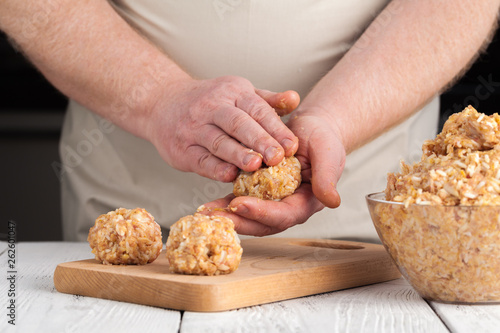 hands prepare meatballs from chicken meat