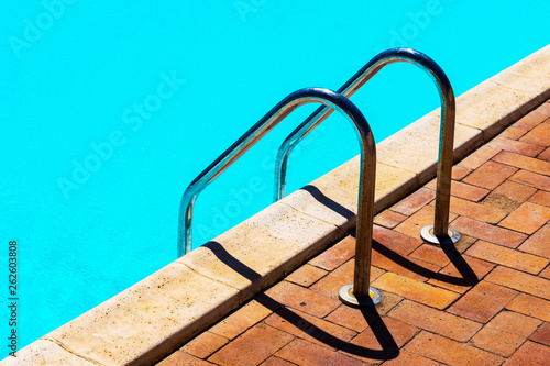 Fototapeta Naklejka Na Ścianę i Meble -  Grab bars ladder in the blue swimming pool