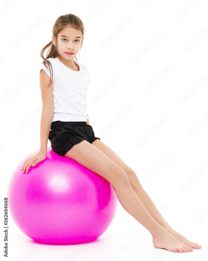 little girl doing exercises on a big ball for fitness. little girl doing exercises on a big ball for fitness.