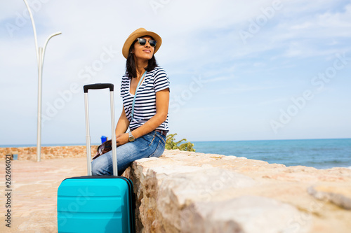 Young indian woman sitting in front of the sea