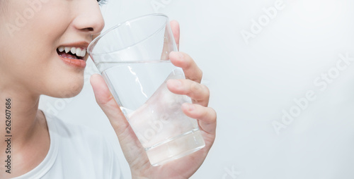 Obraz na płótnie Close up portrait of asian beautiful woman drinking glass of mineral clean water isolated on white background