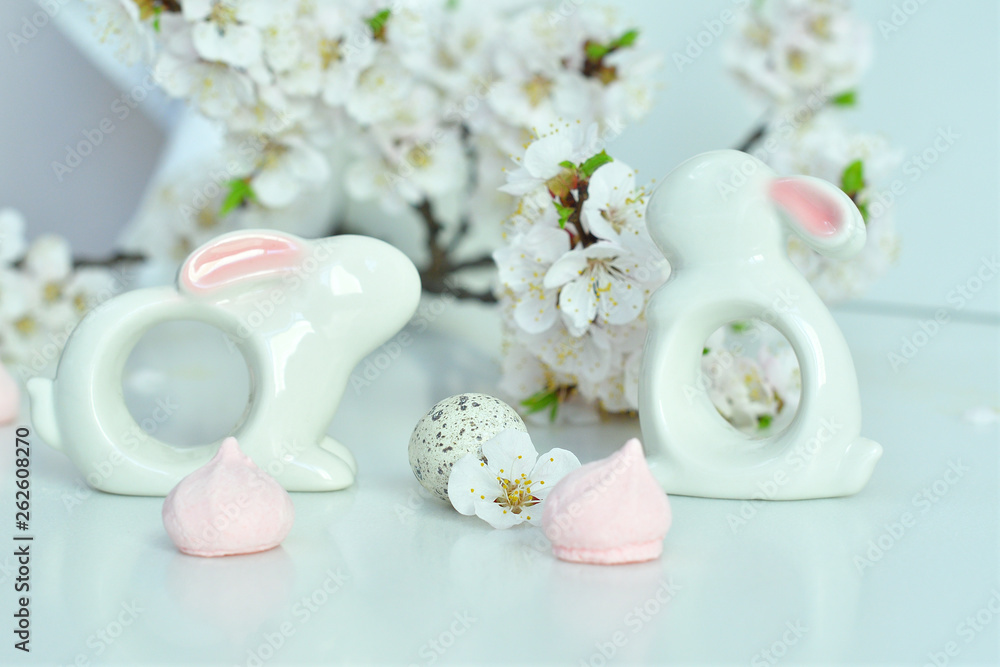 Easter composition on white background.Ceramic rabbit , quail eggs and homemade cookies in the form of bunnies.apricot flowers Easter composition on white background.Ceramic rabbit , quail eggs and homemade cookies in the form of bunnies.apricot flowers