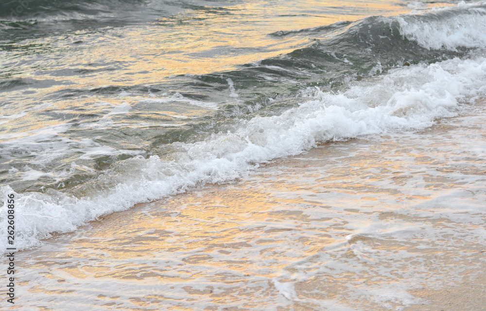 Fototapeta premium Beautiful soft waves of Blue Ocean with Sandy Beach Background close up. Sea sand wallpaper