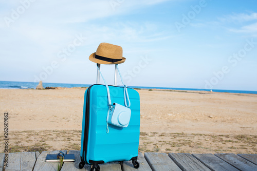 Close-up of blue luggage in front of the sea