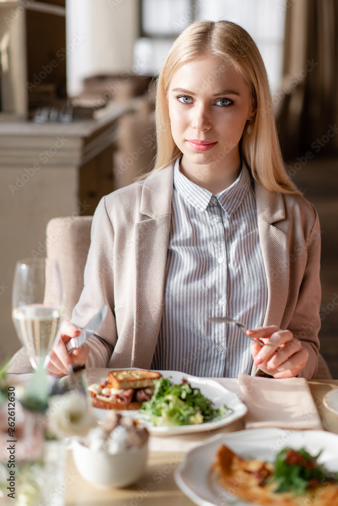Nice woman eat breakfast in cafe. Portrait of young charming female drinking coffee and toasted sandwich in modern coffee shop. Nice woman eat breakfast in cafe. Portrait of young charming female drinking coffee and toasted sandwich in modern coffee shop.