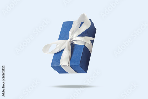 Flying gift box on a light blue background. Holiday concept, gift, sale, wedding and birthday.