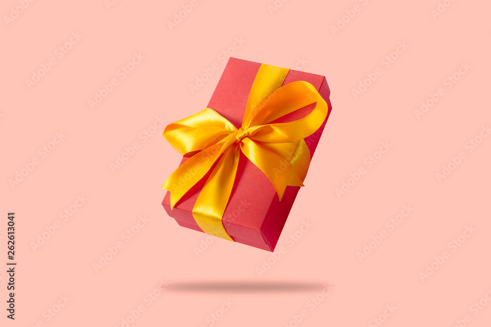 Flying gift box on a light pink background. Holiday concept, gift, sale, wedding and birthday. Flying gift box on a light pink background. Holiday concept, gift, sale, wedding and birthday.