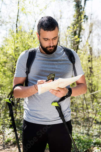 Male hiker using a map to locate the destination