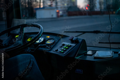 The driver behind the wheel of a trolley bus in the dark