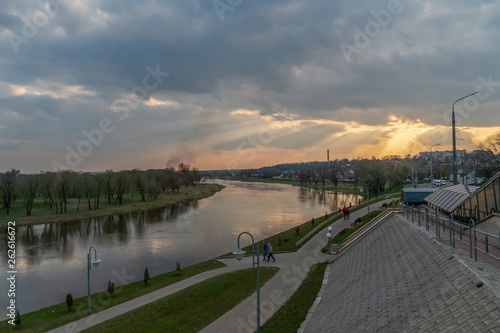 Asphalt road and modern cityscape at sunset. Cityscape with river at sunset