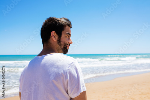 young man looking aside on the beach