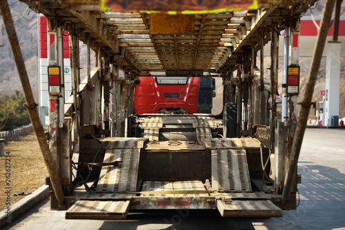 Close-up view at interior of old, unloaded transporting cars truck stopped at gas station.