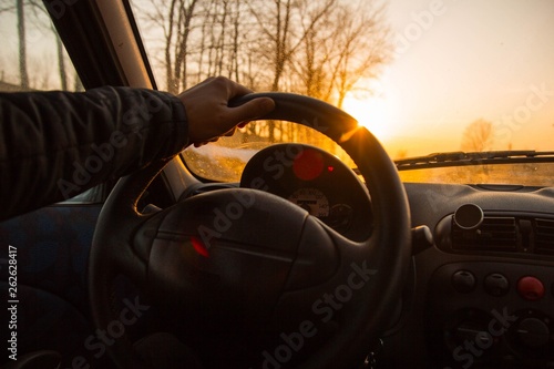 driving a car on a hot summer sunny day. hands of the driver behind the wheel.