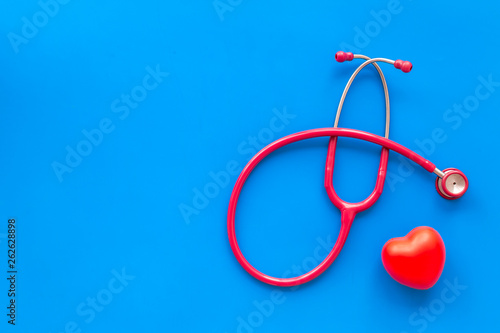 stethoscope and heart for diagnostic and cure of heart disease on blue background top view mockup