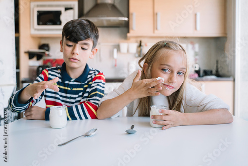 Two kids eating a healthy yoghurt breakfast