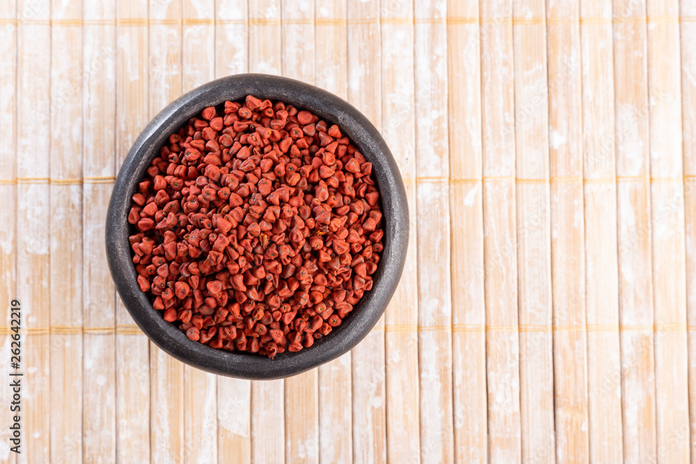 Annatto seeds on rustic wood