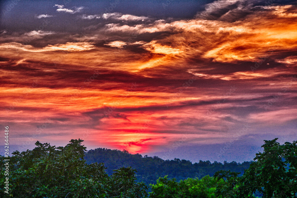 Dieses einzigartige Bild zeigt den schönen roten Sonnenuntergang mit großer Wolkenbildung hinter den Bergen in Hua Hin in Thailand