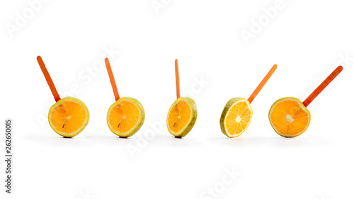 sliced orange fruit on a stick. white background