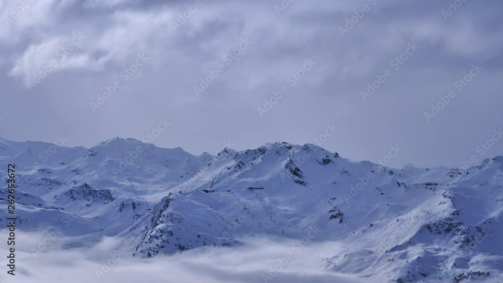 Timelapse of clouds moving over mountains with ski lifts in the distance. In the ski resort of Meribel in the French Alps in winter. Timelapse of clouds moving over mountains with ski lifts in the distance. In the ski resort of Meribel in the French Alps in winter.