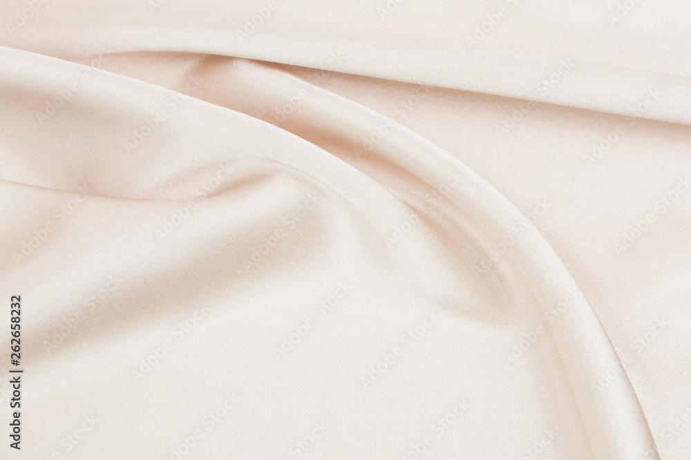 The texture of the satin fabric of beige color for the background The texture of the satin fabric of beige color for the background