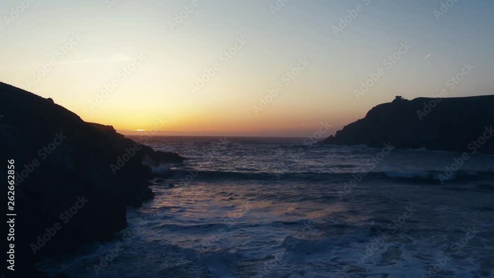 Drone captures a setting sun at golden hour over a lonely cove. Haze and setting sun create a dreamy and surreal vibe. Drone captures a setting sun at golden hour over a lonely cove. Haze and setting sun create a dreamy and surreal vibe.