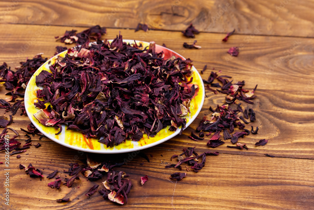 Dried hibiscus (carcade, roselle) on wooden table Dried hibiscus (carcade, roselle) on wooden table