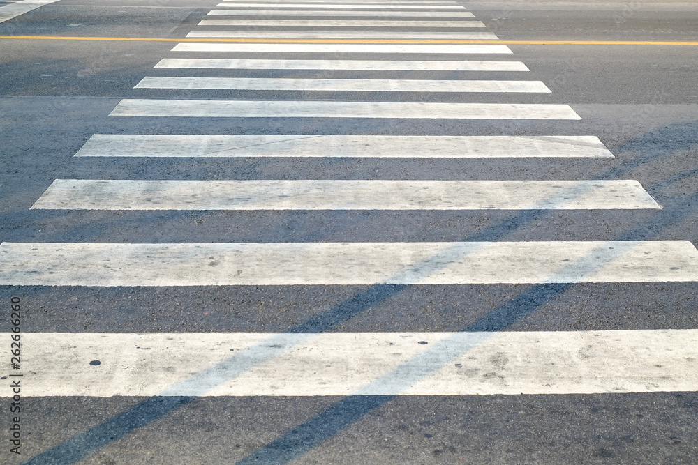 crosswalk on the road for safety when people walking cross the street, Pedestrian crossing on a repaired asphalt road, Crosswalk on the street for safety. 