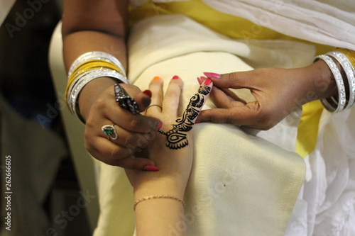 Indian girl in sare makes mehndi on henna hand