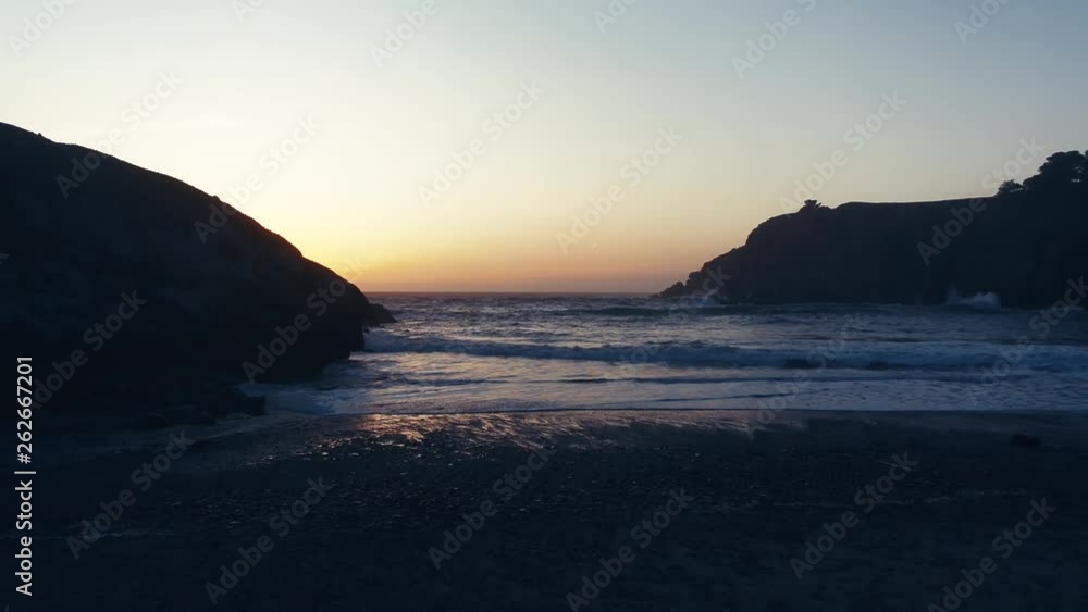 Drone captures a setting sun at golden hour over a lonely cove. Haze and setting sun create a dreamy and surreal vibe. Drone captures a setting sun at golden hour over a lonely cove. Haze and setting sun create a dreamy and surreal vibe.