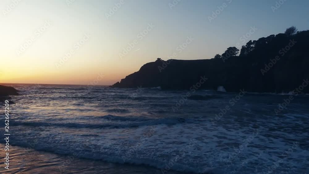 Drone captures a setting sun at golden hour over a lonely cove. Haze and setting sun create a dreamy and surreal vibe. Drone captures a setting sun at golden hour over a lonely cove. Haze and setting sun create a dreamy and surreal vibe.