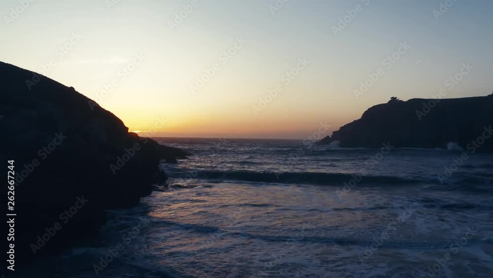 Drone captures a setting sun at golden hour over a lonely cove. Haze and setting sun create a dreamy and surreal vibe. Drone captures a setting sun at golden hour over a lonely cove. Haze and setting sun create a dreamy and surreal vibe.