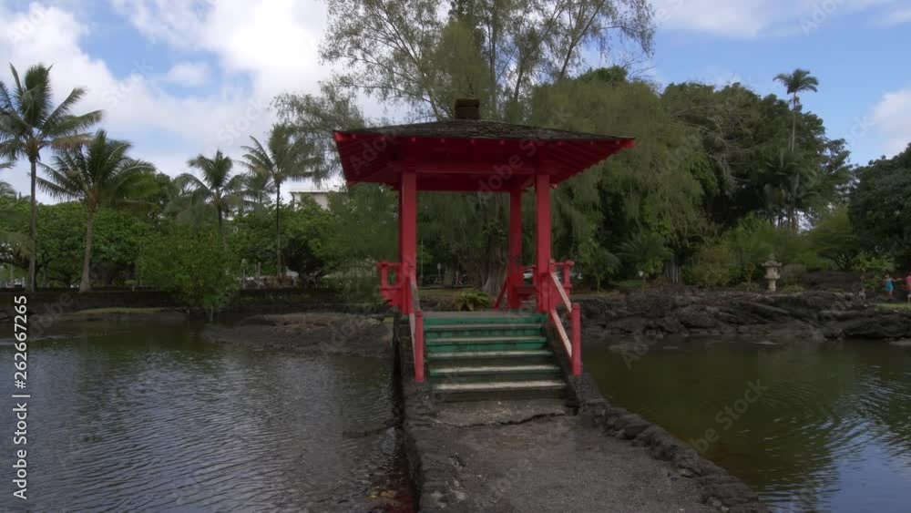 Liliuokalani zen garden in hilo hawaii, a relaxing walk past a statue and over a japanses style wooden bridge Liliuokalani zen garden in hilo hawaii, a relaxing walk past a statue and over a japanses style wooden bridge