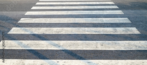 crosswalk on the road for safety when people walking cross the street, Pedestrian crossing on a repaired asphalt road, Crosswalk on the street for safety. 