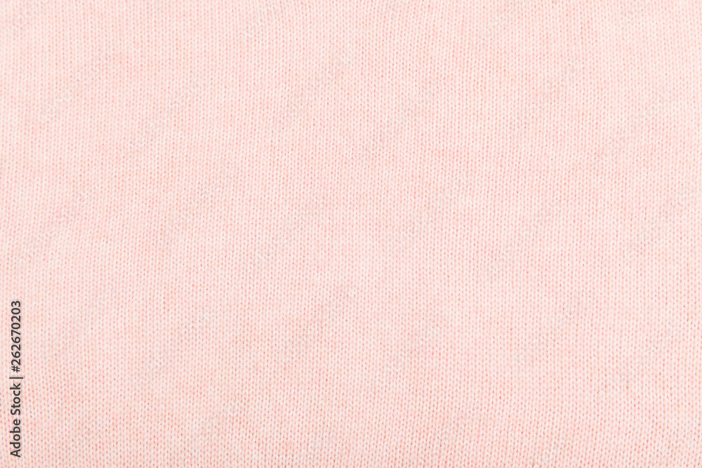 Fototapeta premium closeup of pink knitted fabric texture. facial loops. stockings with knitting needles and pink woolen thread