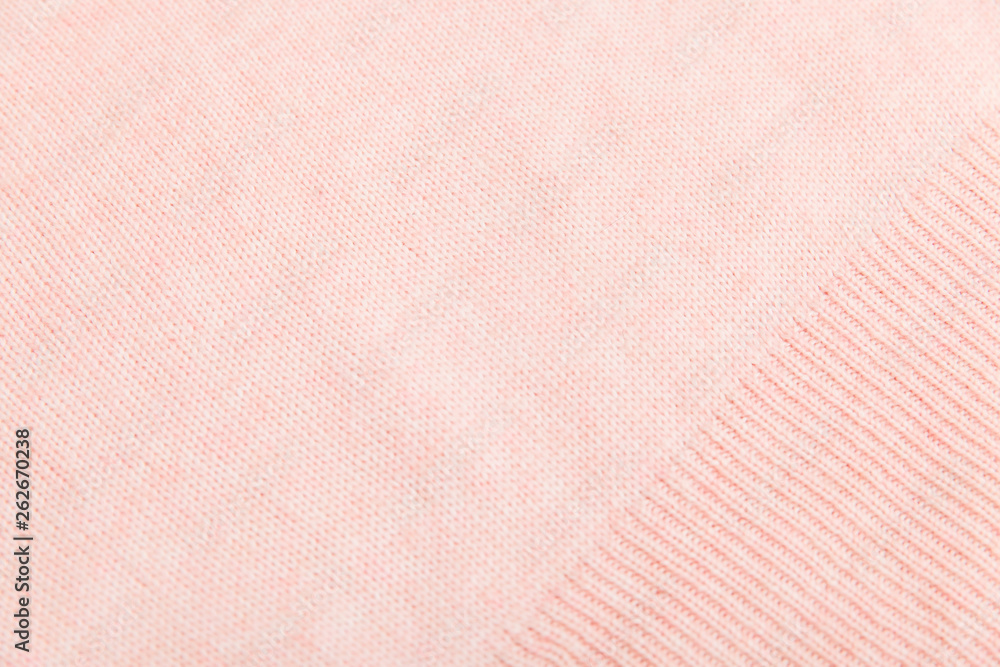 Fototapeta premium closeup of pink knitted fabric texture. facial loops. stockings with knitting needles and pink woolen thread