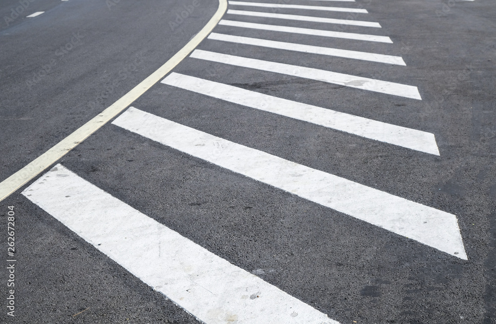 crosswalk on the road for safety when people walking cross the street, Pedestrian crossing on a repaired asphalt road, Crosswalk on the street for safety. 