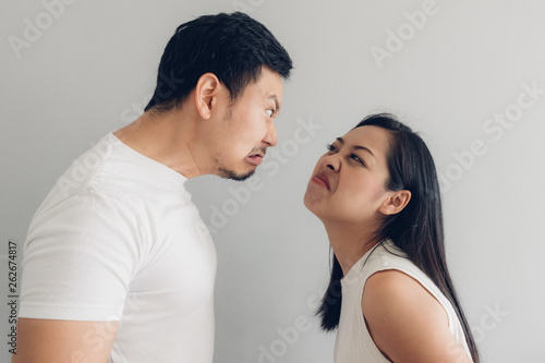 Angry couple lover in white t-shirt and grey background.