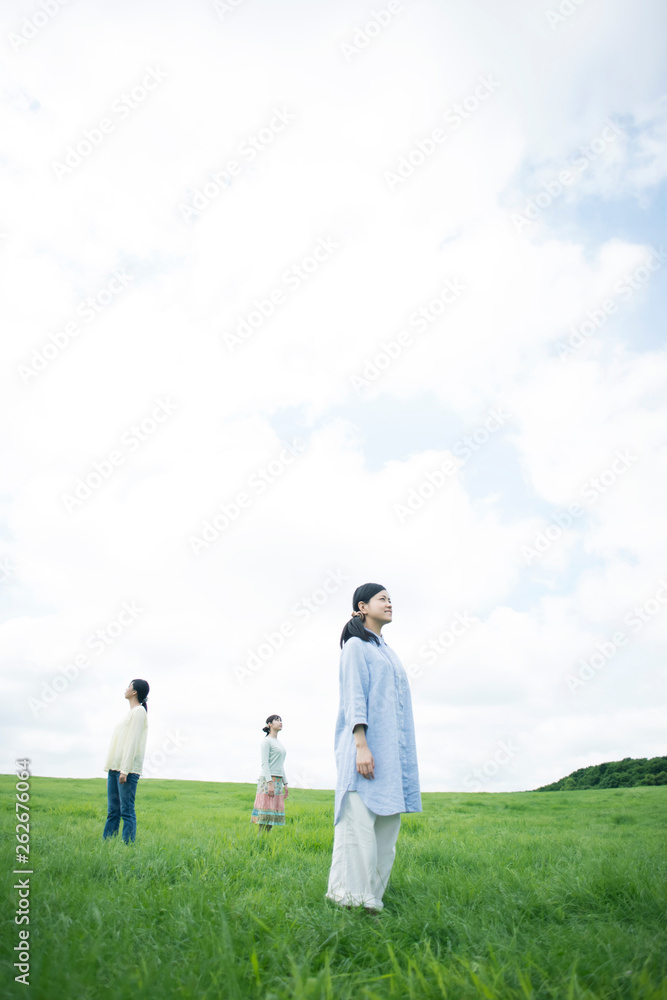 草原に佇む3人の女性