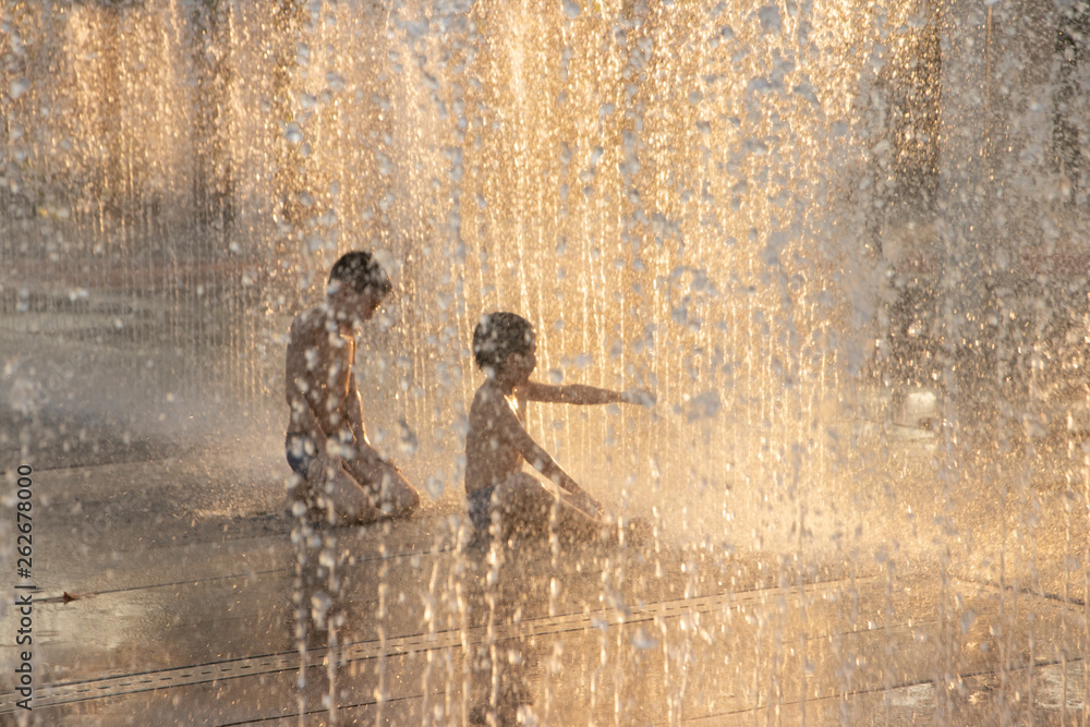  kid and friend having fun to play the fountain park 