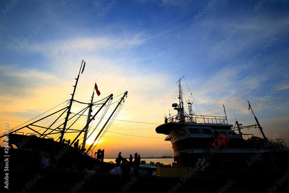 Fishing boats silhouetted against the setting sun Fishing boats silhouetted against the setting sun