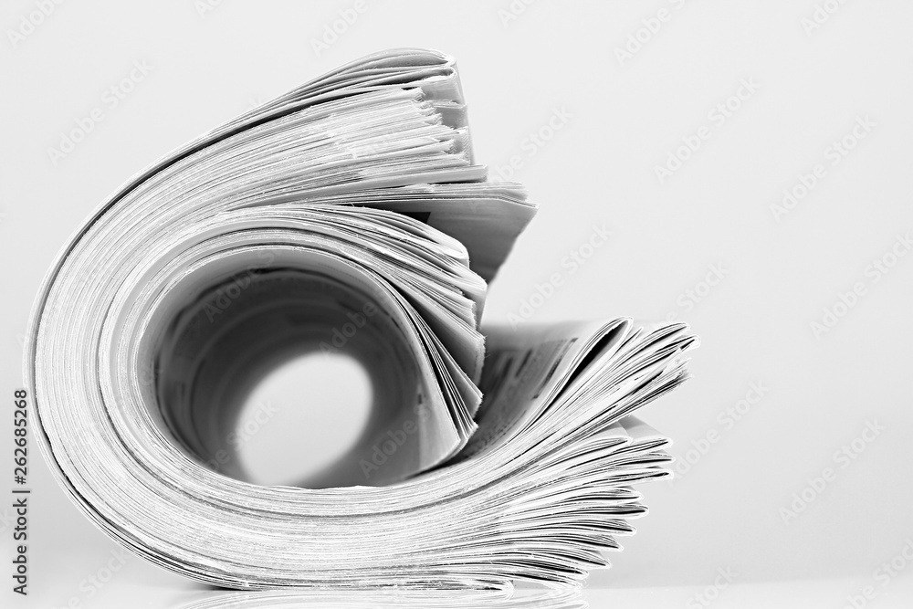 newspaper rolled up and sitting on a table