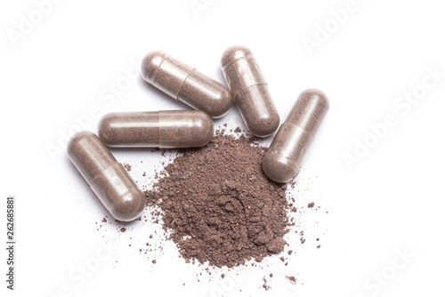 Herbal medicine in capsule isolate on white background. Herb black Galingale powder extract. Herbal medicine with open clear capsules. Alternative supplement for good healthy.