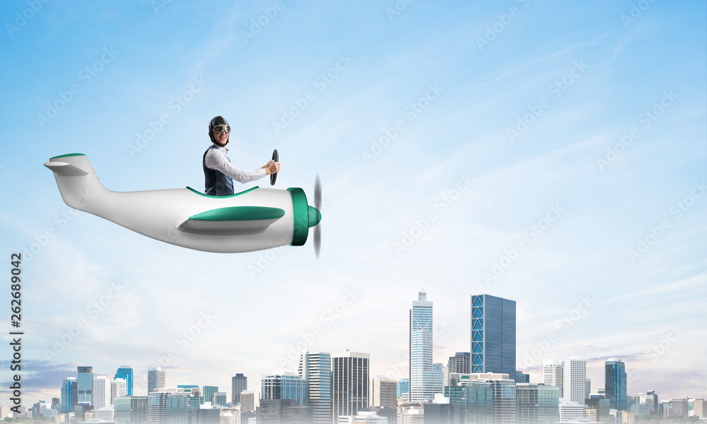 Businessman driving propeller plane above downtown Businessman driving propeller plane above downtown