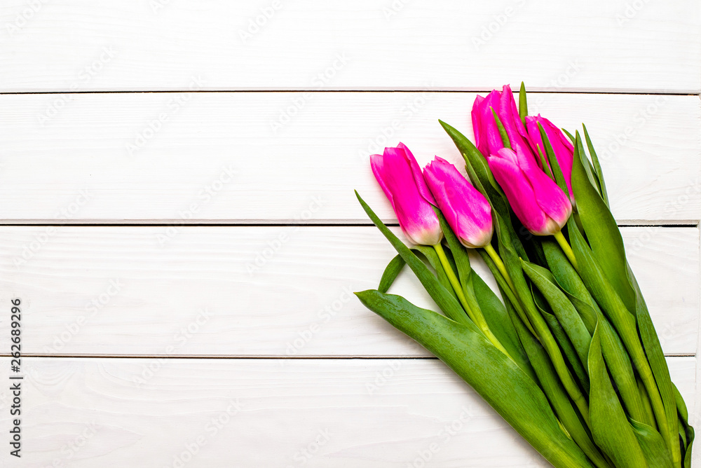 Fototapeta premium Bouquet of pink tulips on white wooden background