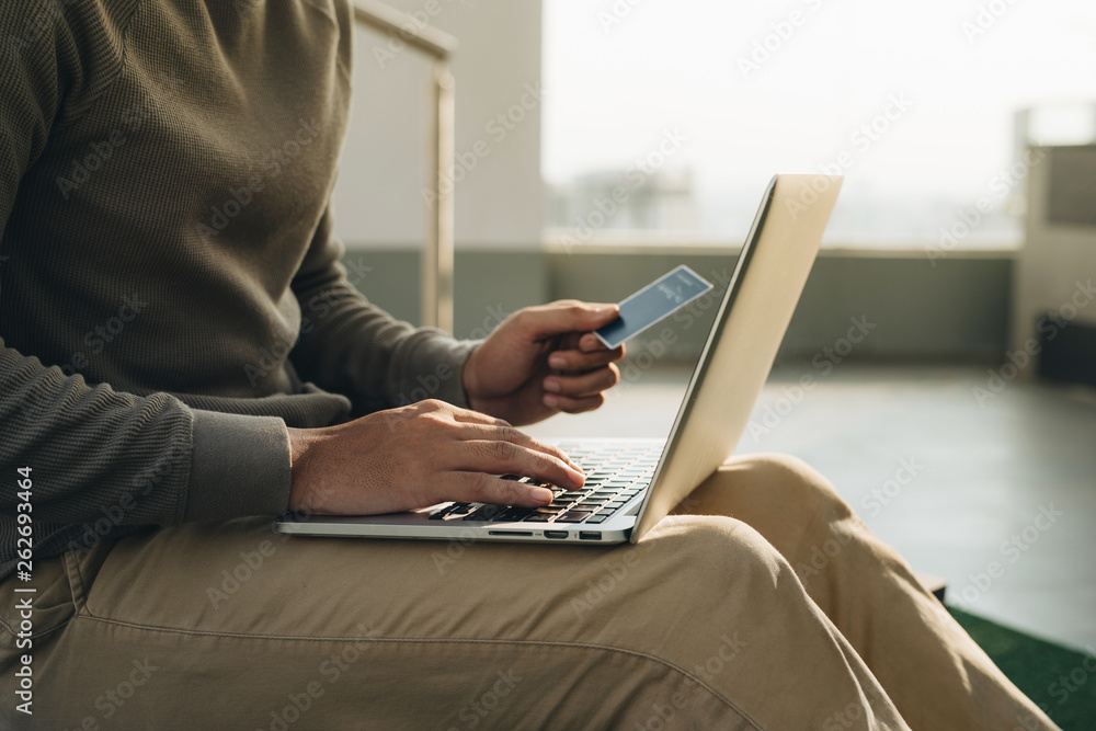 a businessman sitting with the laptop on his knees and hand takes the card a businessman sitting with the laptop on his knees and hand takes the card