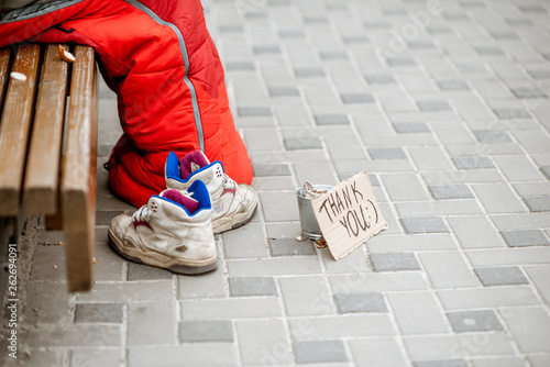 Beggar asking some money with cup and thank you cardboad on the street, close-up view photo